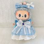 A plush doll wearing a light blue dress with white lace trim and a large white bow at the waist.  