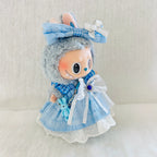A cute Labubu plush doll wearing a light blue plaid dress with white lace trim, a large white bow, and a blue bunny keychain.