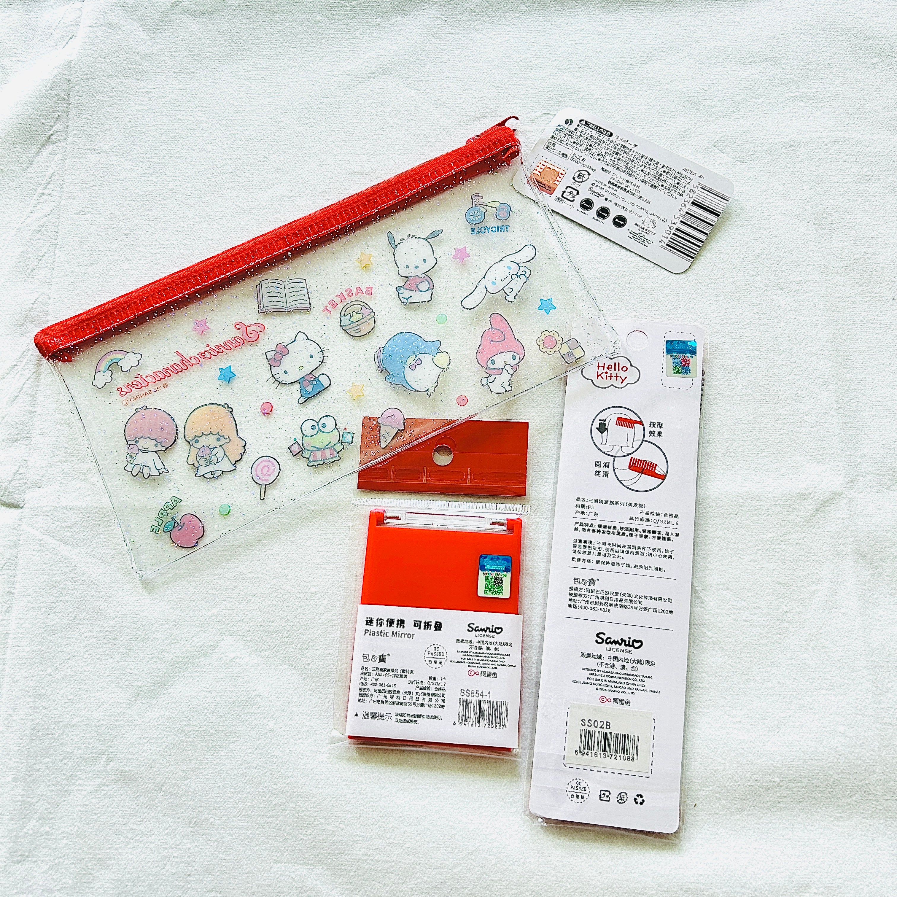A back view of the Sanrio Hello Kitty themed personal care set. Show the licensed holographic sticker of the compact mirror and a comb. 