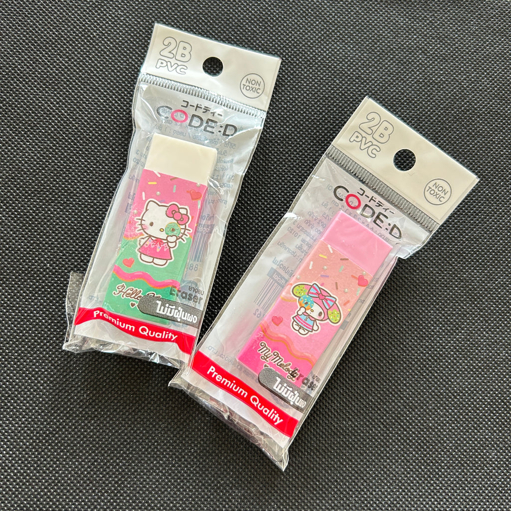Two packaged PVC erasers featuring Hello Kitty and Sanrio characters, displayed on a dark textured background.