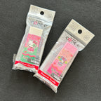 Two packaged PVC erasers featuring Hello Kitty and Sanrio characters, displayed on a dark textured background.