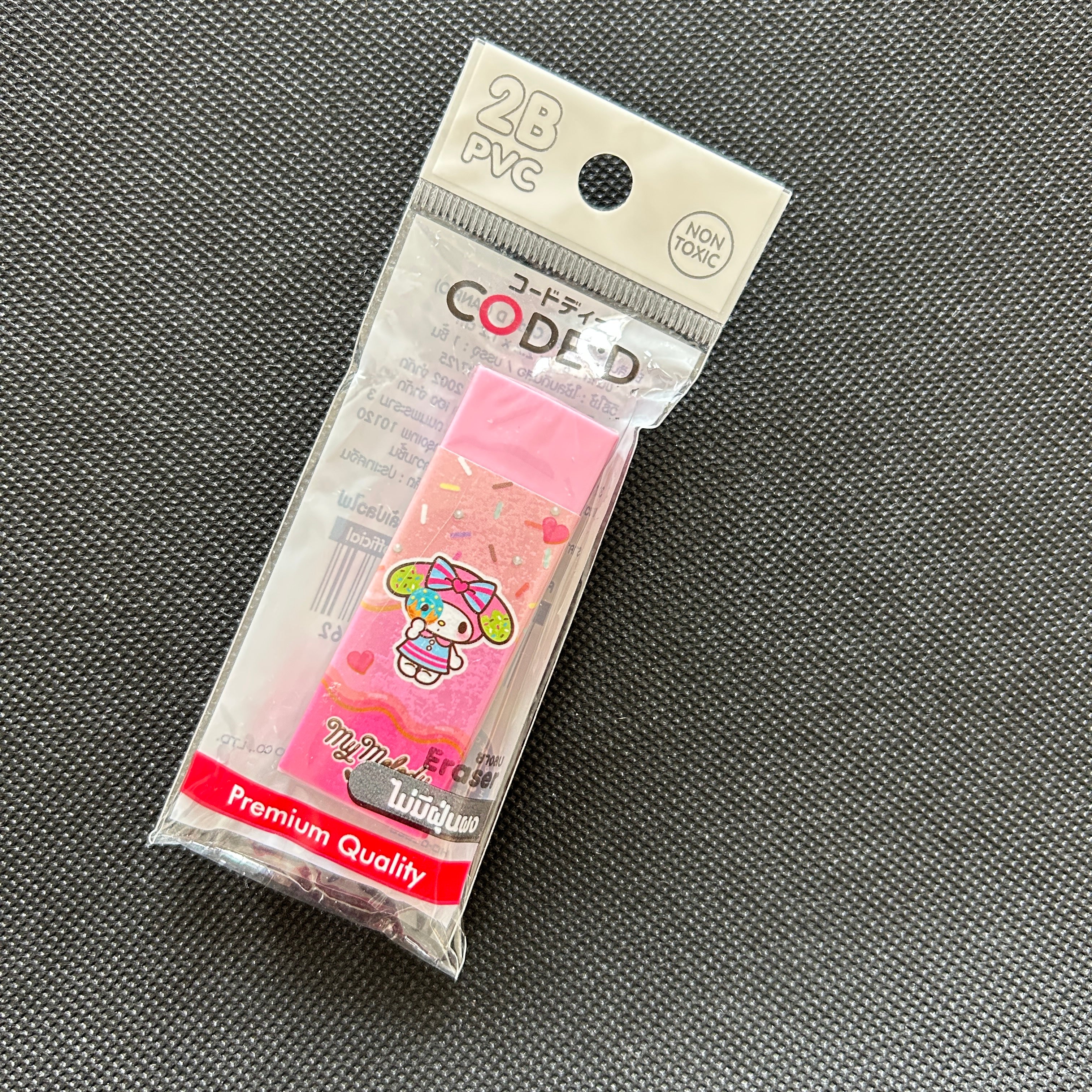 A packaged set of 28 pink PVC code-tape sections featuring a cute character design, sealed in a clear plastic bag with a white header card, placed on a dark gray textured surface.