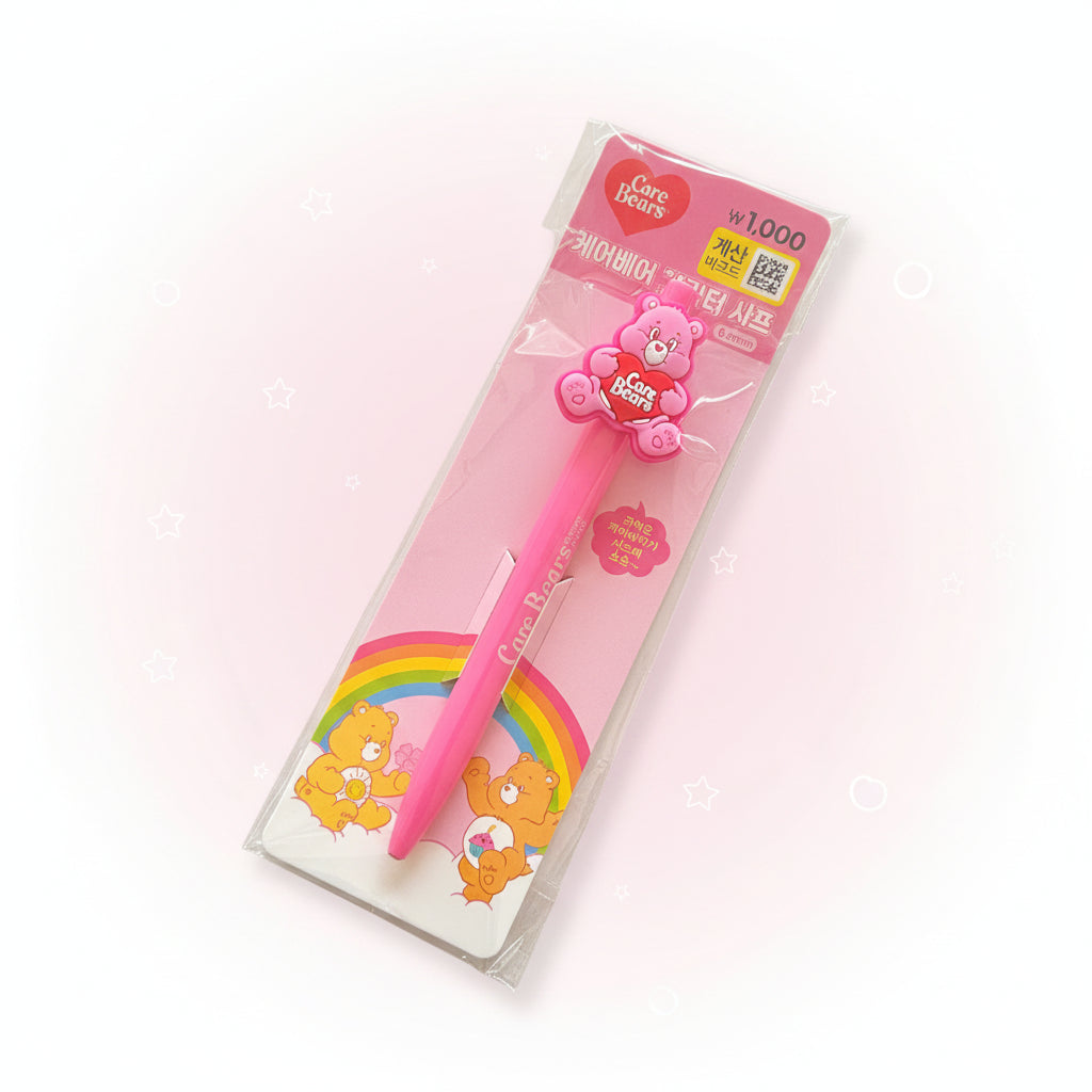 A pink Care Bears pen in its original retail packaging, featuring a 3D bear charm and a rainbow design on the card backing.