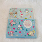 A stack of Sanrio Hello Kitty and Sanrio Cinnamoroll Letter Set, shows the product packaging with a Hello Kitty strawberry-themed design, and the bottom sheet displays the actual sticker collection featuring Hello Kitty, My Melody, Cinnamoroll, and a blue penguin.