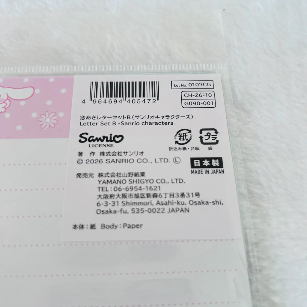 A close-up of a Sanrio Letter Set B paper envelope or card packaging, showing a pink and white label with a barcode, product code CH-26/10, and Sanrio branding on a white textured background.