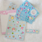 A set of Sanrio Hello Kitty and duo-style character letter set  arranged on a white textured fabric background, including a envelopes,  letter papers and stickers.