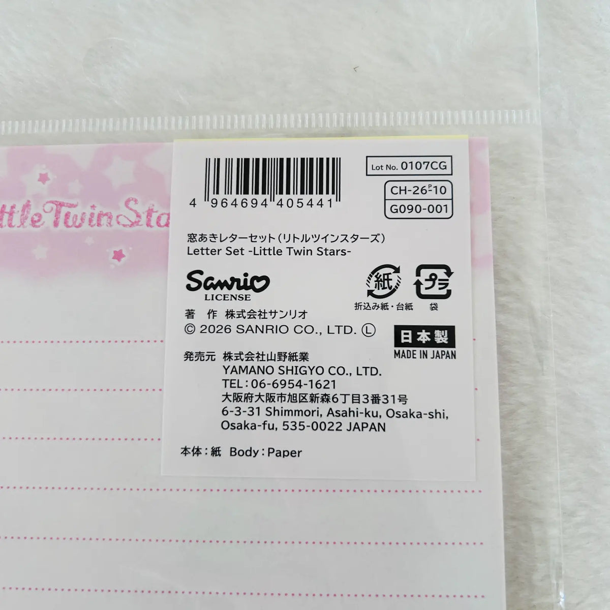 A close-up of a Sanrio Little Twin Stars letter set paper card, showing the back side with a barcode, product code CH-26510, Japanese text, and a pink border.