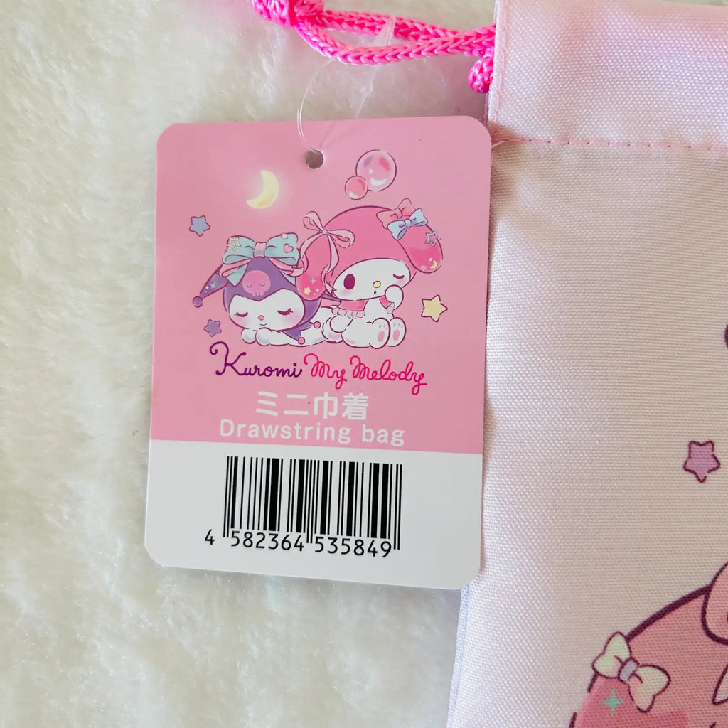 A pink drawstring bag with a Kuromi My Melody tag attached, photographed close-up on a white textured surface. The tag shows the character artwork and text 'Kuromi My Melody' and 'Drawstring bag'.