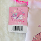 A pink drawstring bag with a Kuromi My Melody tag attached, photographed close-up on a white textured surface. The tag shows the character artwork and text 'Kuromi My Melody' and 'Drawstring bag'.