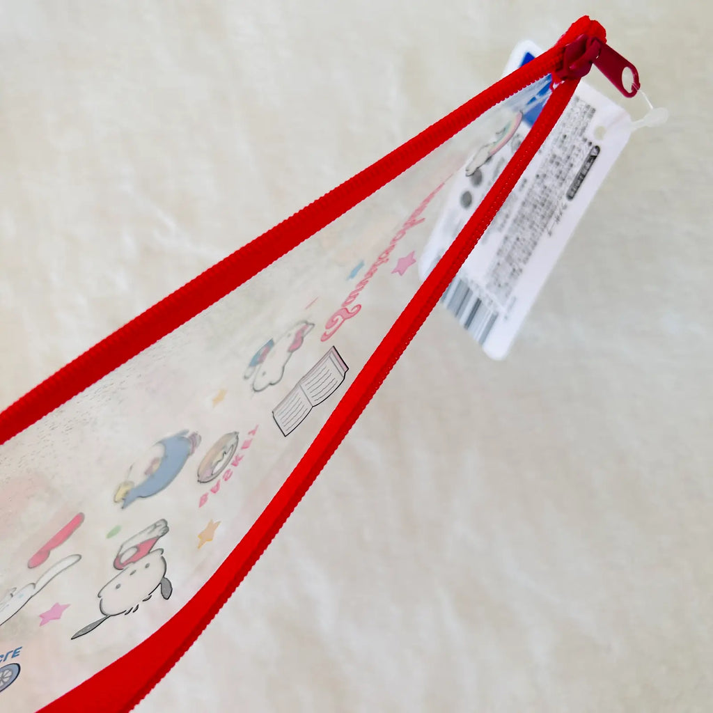 A clear plastic pencil case with a bright red zipper and red loop, decorated with cute cartoon characters and Japanese text.