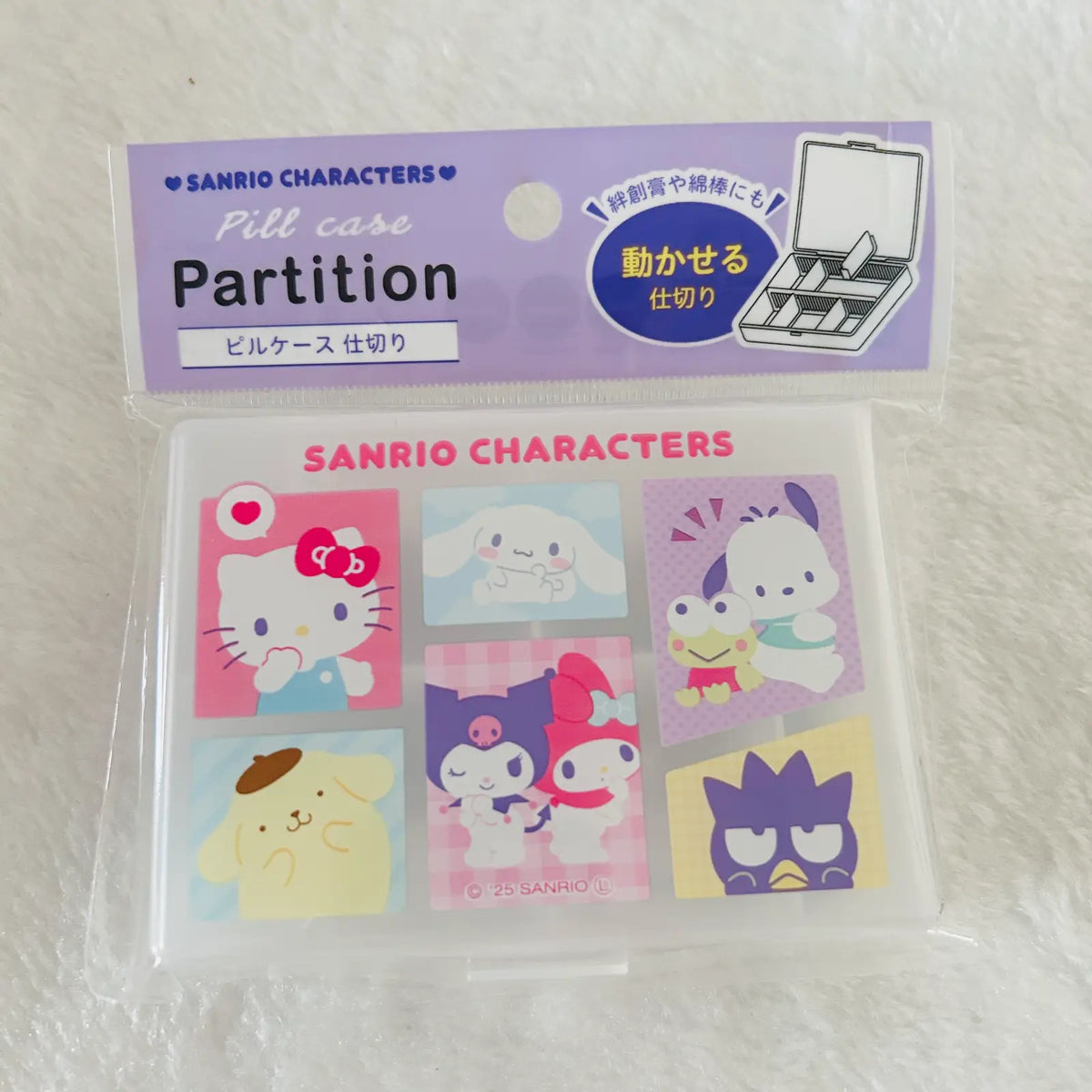 A Sanrio Characters Pill Case Partition in its original packaging, featuring cartoon characters like Hello Kitty, My Melody, and Kuromi on a white textured background.