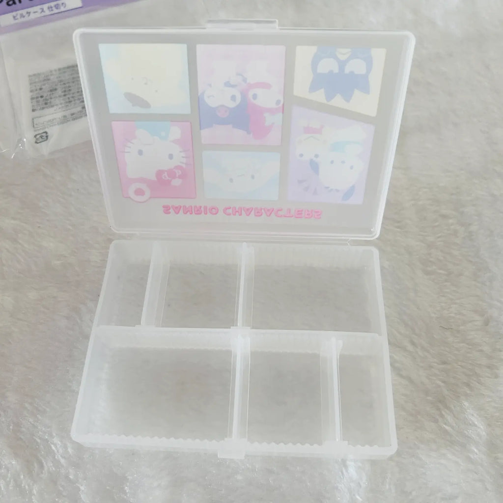 A translucent white plastic organizer box with six compartments in the base and a hinged lid decorated with pastel Sanrio character illustrations, including Hello Kitty, shown on a white textured surface.