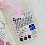 A close-up of a Hello Kitty product tag attached with a pink braided cord, showing Japanese text, product code 41577, and Sanrio branding on a white fabric background.