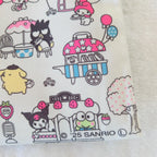 A close-up of a fabric or paper print featuring Sanrio character illustrations, including Kuromi, My Melody, and Pompompurin, in a picnic-themed pattern on a white background.
