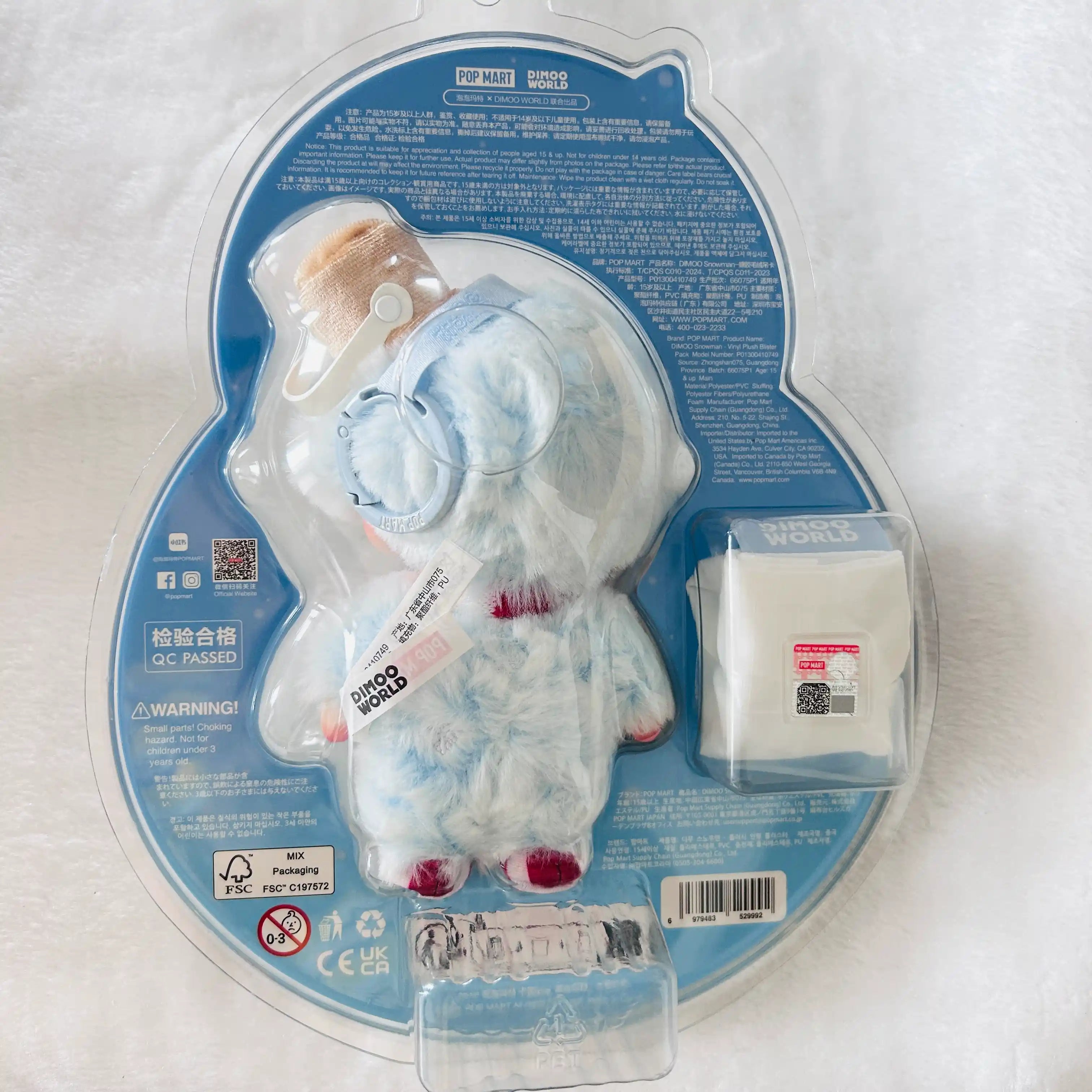 A packaged Dimoo Snowmanplush toy in a clear blister pack on a blue backing card. 