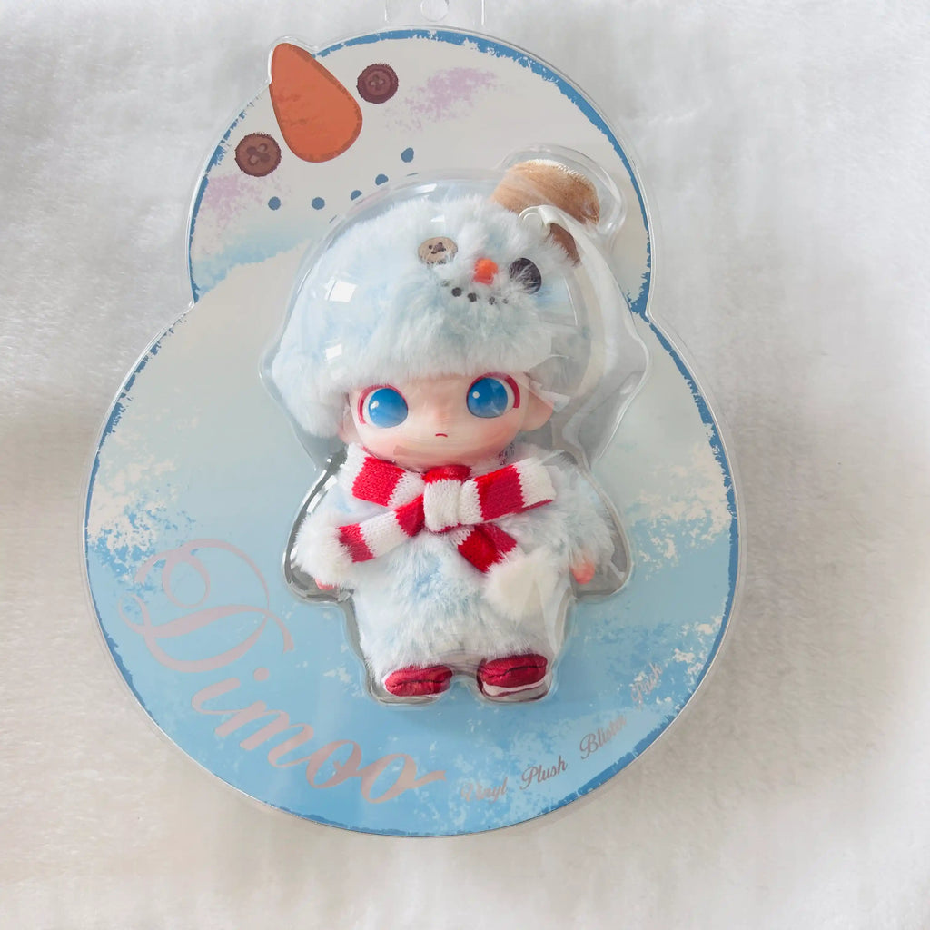 A Dimoo plush doll in a clear blister pack on a Snowman shaped backing card.