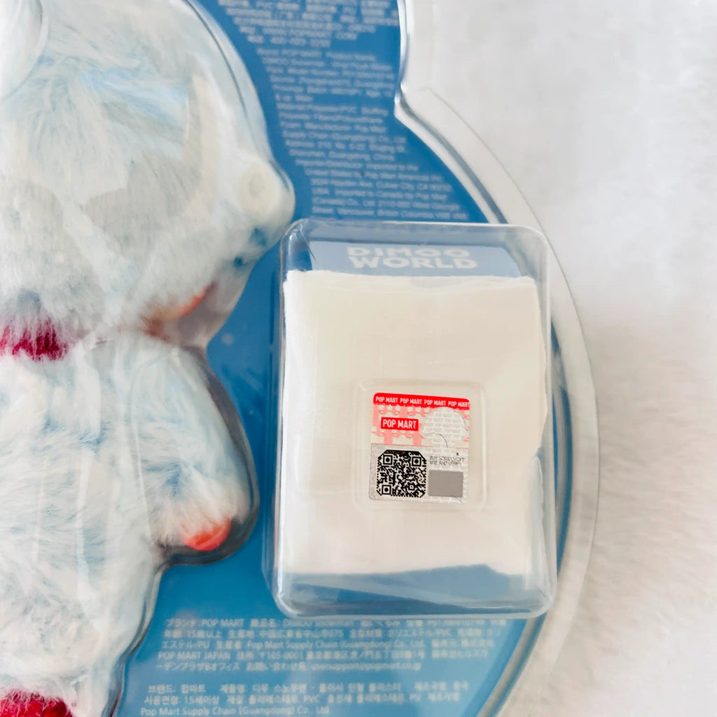 A packaged of Dimoo Snowman plush toy, shows a small red label on the package reads 'POP MART' with QR code.