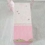 A pink and white decorative gift box with butterfly and flower illustrations, photographed on a soft white textured surface.