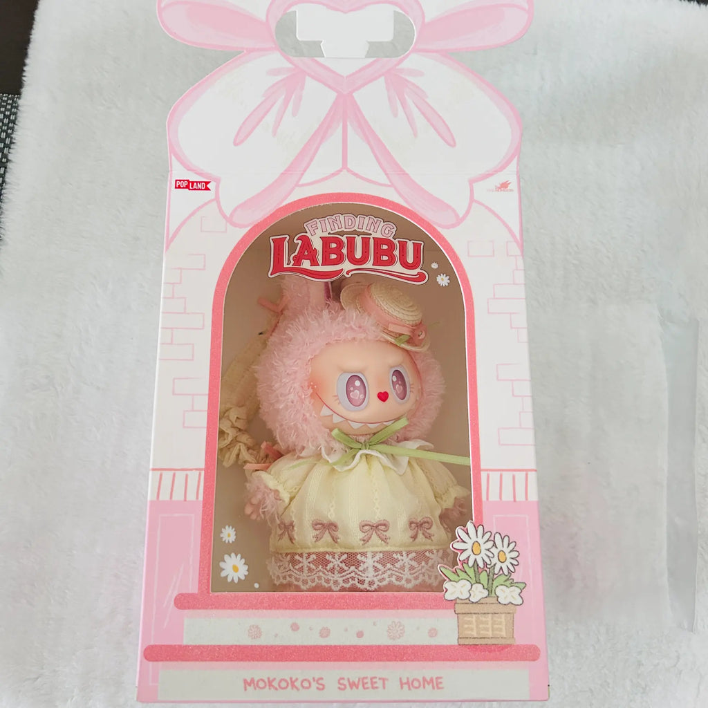 A pink and white LALUBU 'Mokoko's Sweet Home' collectible doll figure in its original retail packaging, displayed on a white textured fabric background.