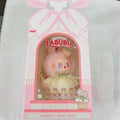 A pink and white LALUBU 'Mokoko's Sweet Home' collectible doll figure in its original retail packaging, displayed on a white textured fabric background.