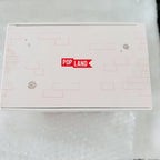 A square white product box with a red 'POP LAND' logo on the lid, decorated with light pink block patterns and small flower illustrations, resting on a white textured surface.