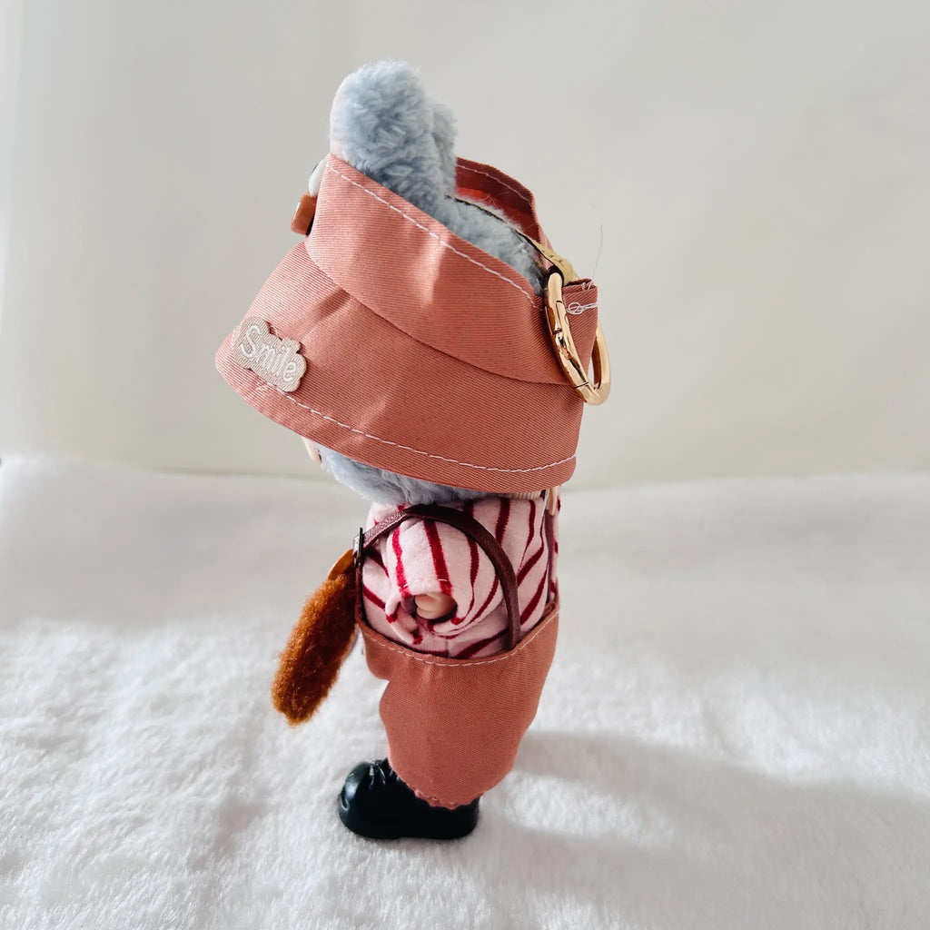 A Labubu doll wearing a dusty coral wide-brim hat, a pink-and-white striped shirt, and black shoes.