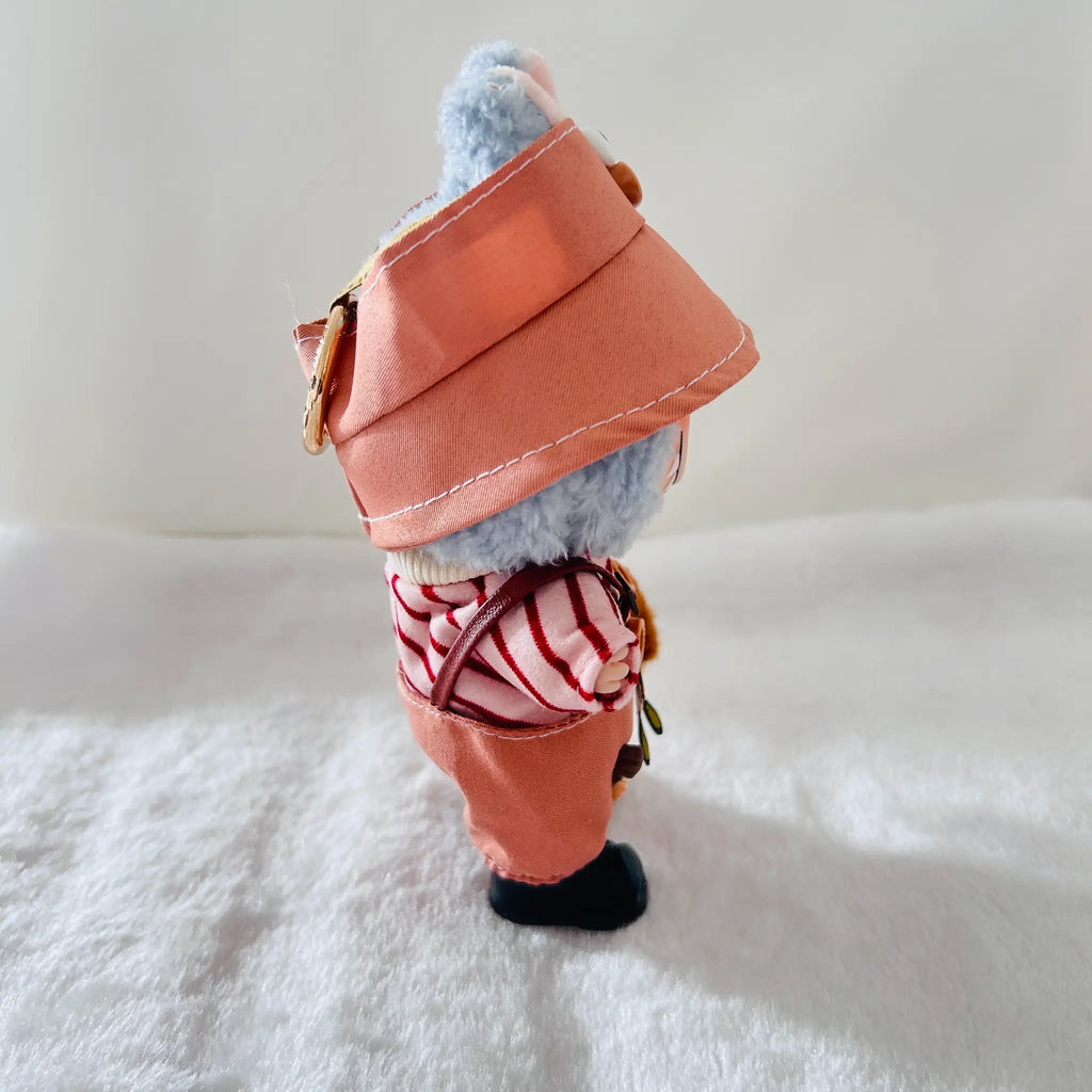 A back view of a Labubu doll wearing a dusty coral overalls, a red-and-white striped top, and black boots. 