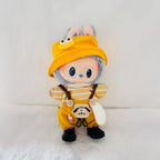 A Labubu plush doll dressed in a yellow outfit with a striped shirt, brown suspenders, black boots, and a yellow bucket hat.
