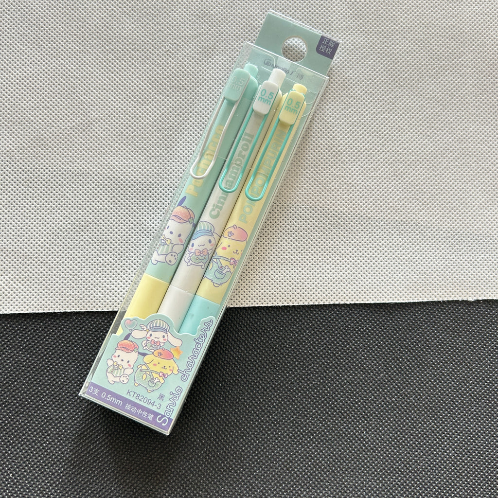 A packaged set of three pastel-colored gel pens with Sanrio character illustrations, resting on a split white and dark gray textured surface.