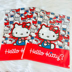Two Hello Kitty file folders on a white faux fur surface. The folders feature a busy red, white, and blue patterned background with a large graphic of Hello Kitty in the center and a solid red bottom band with 'Hello Kitty?' written in white script.
