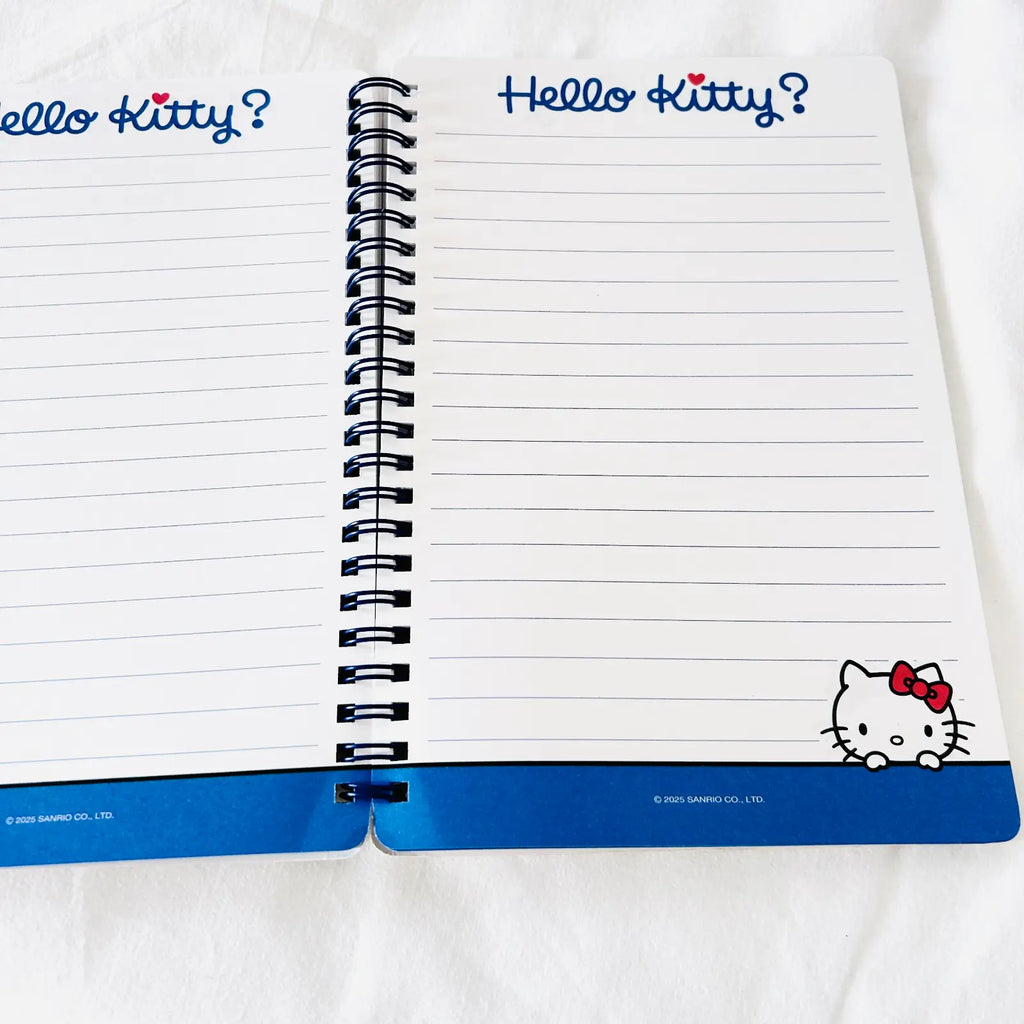 An open Hello Kitty spiral notebook with lined pages, blue header text reading 'Hello Kitty?' at the top, and a blue bottom band featuring a Hello Kitty illustration.