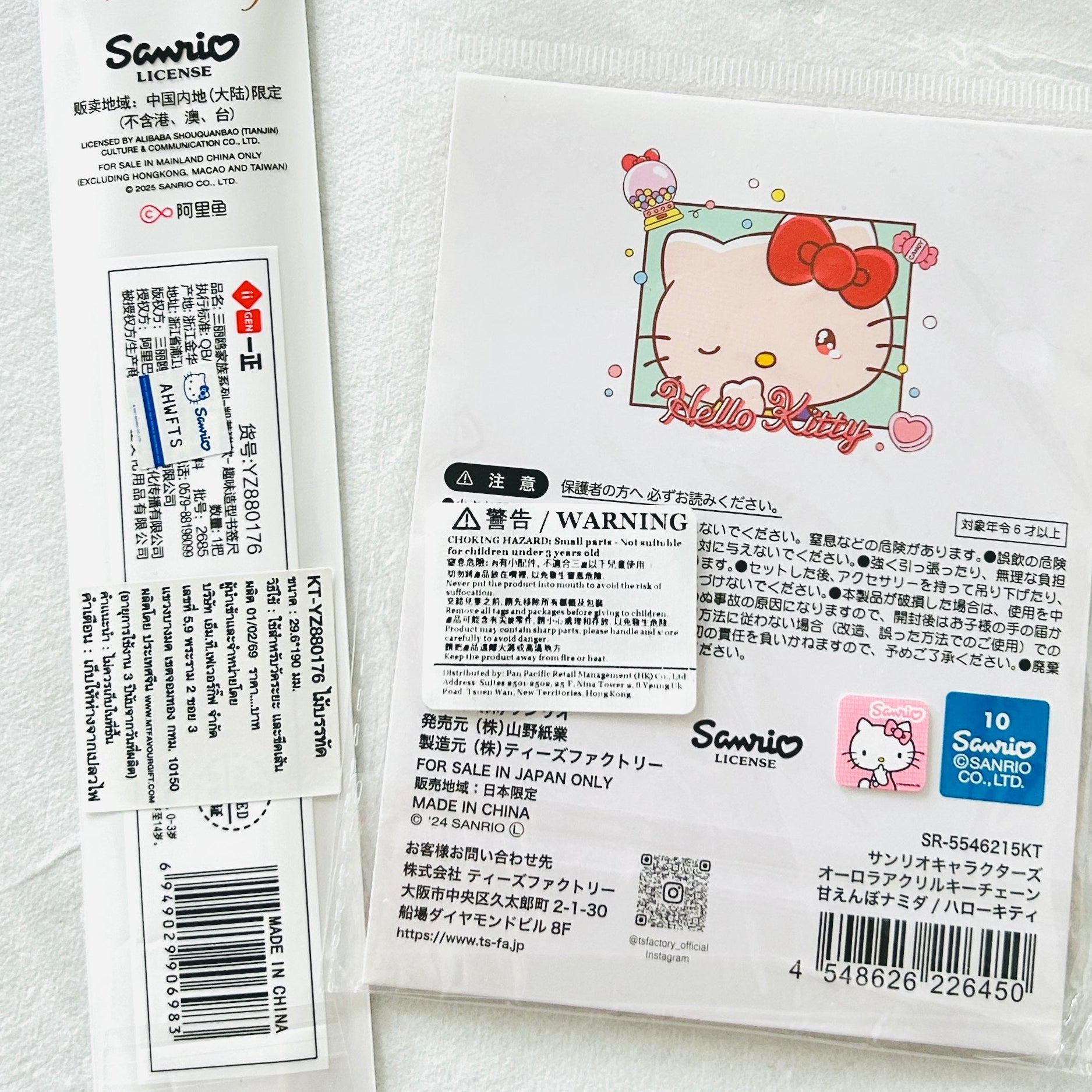 A sealed Sanrio Hello Kitty product package photographed on a white background, showing the back of the packaging with Japanese text, a cartoon Hello Kitty illustration, barcode, QR code, and a blue Sanrio logo block.