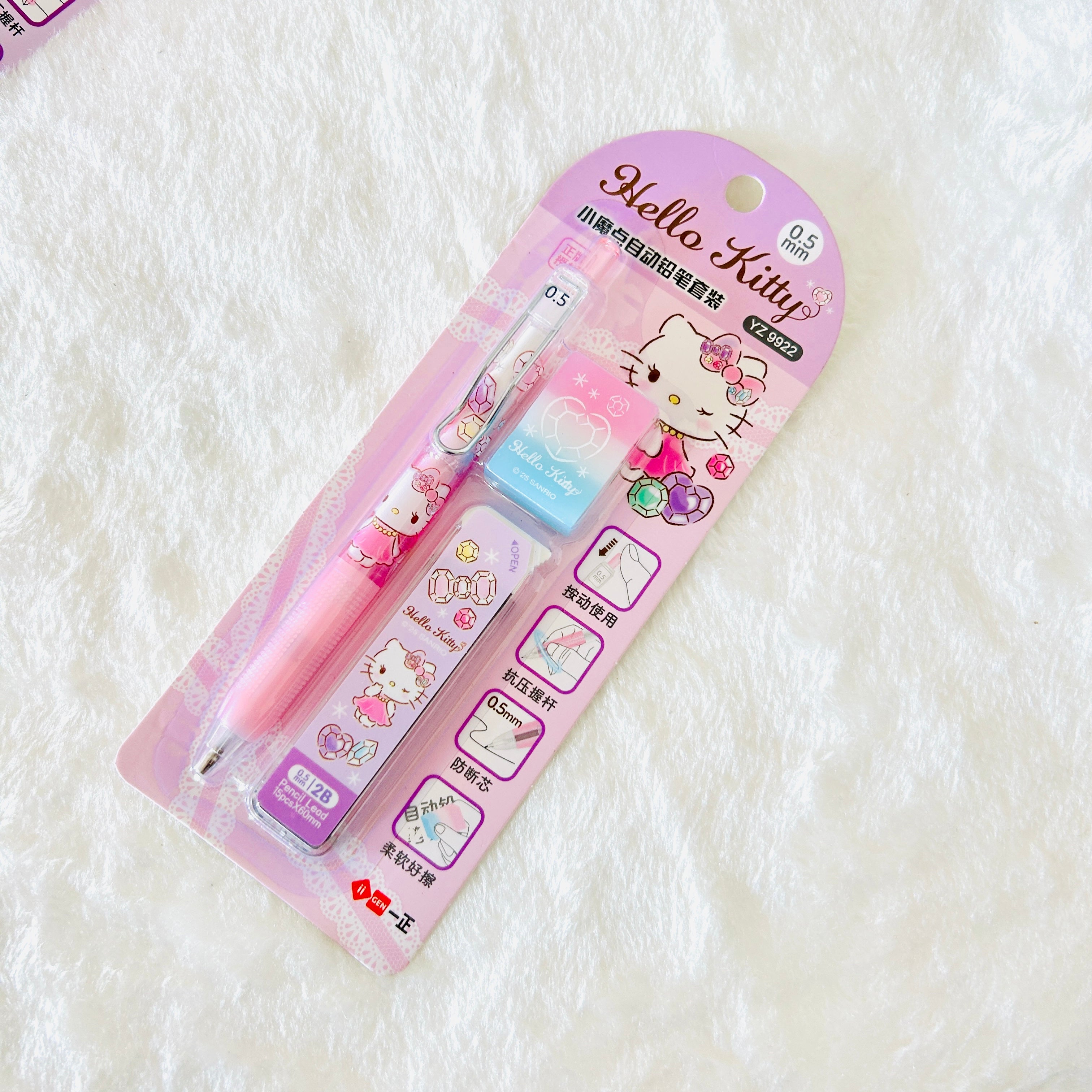 Hello Kitty 0.5mm mechanical pencil with an eraser in its original pink blister packaging, displayed on a white textured fabric background.