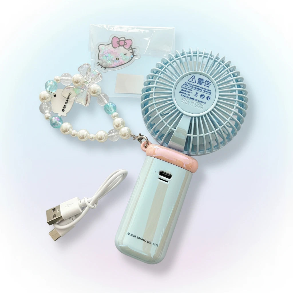 A back view of a light blue portable handheld fan, shown with a pearl-and-bead wrist strap, USB charging cable, and a small Hello Kitty sticker.