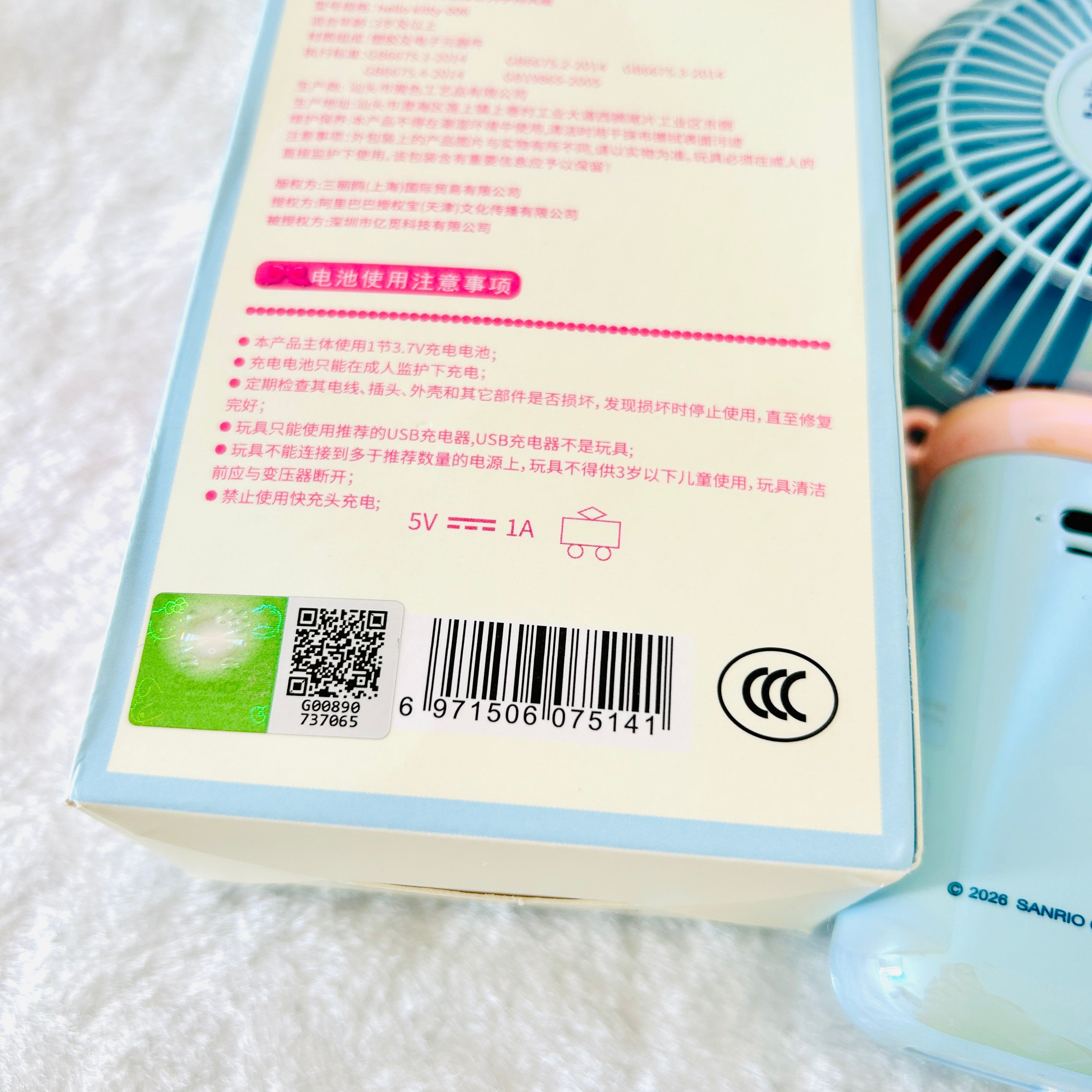 Close-up of the back of the handheld fan product box with Chinese text, a barcode, a QR code, and certification marks. 