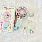 Hello Kitty mini portable fan set with its retail box. The set includes a pastel pink and blue fan, a pearl keychain with Hello Kitty charms, and a USB charging cable.
