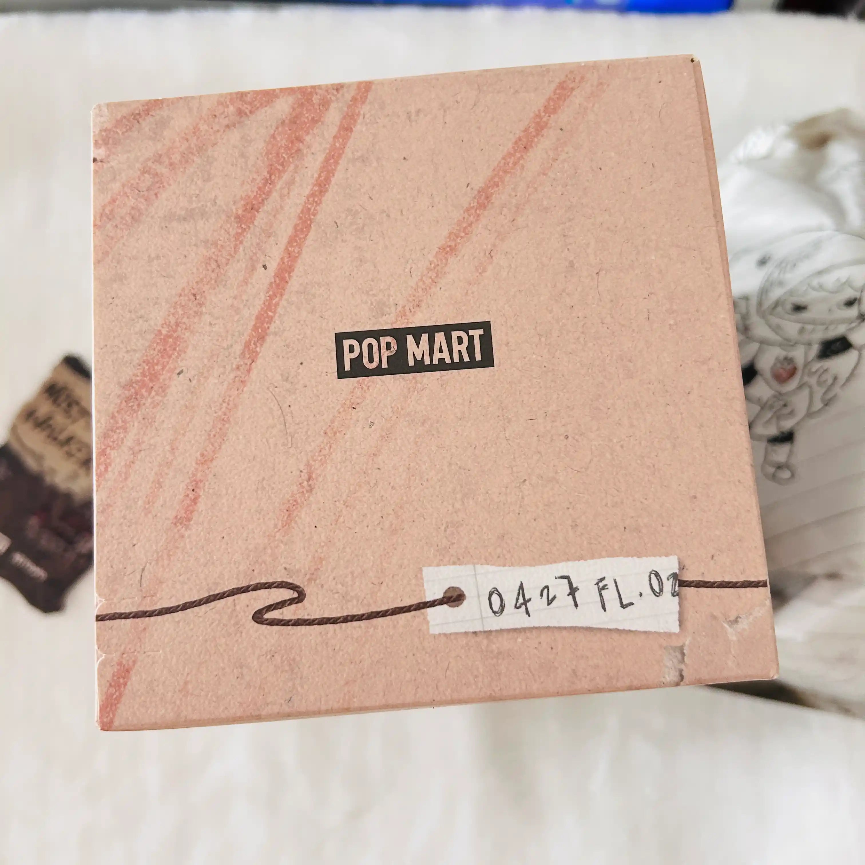 A top view of a paper box with a black 'POP MART' logo.