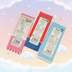 Three packaged craft sticks from Suniso, featuring pink, red, and blue designs with white labels, set against a pastel sky background with clouds and stars.