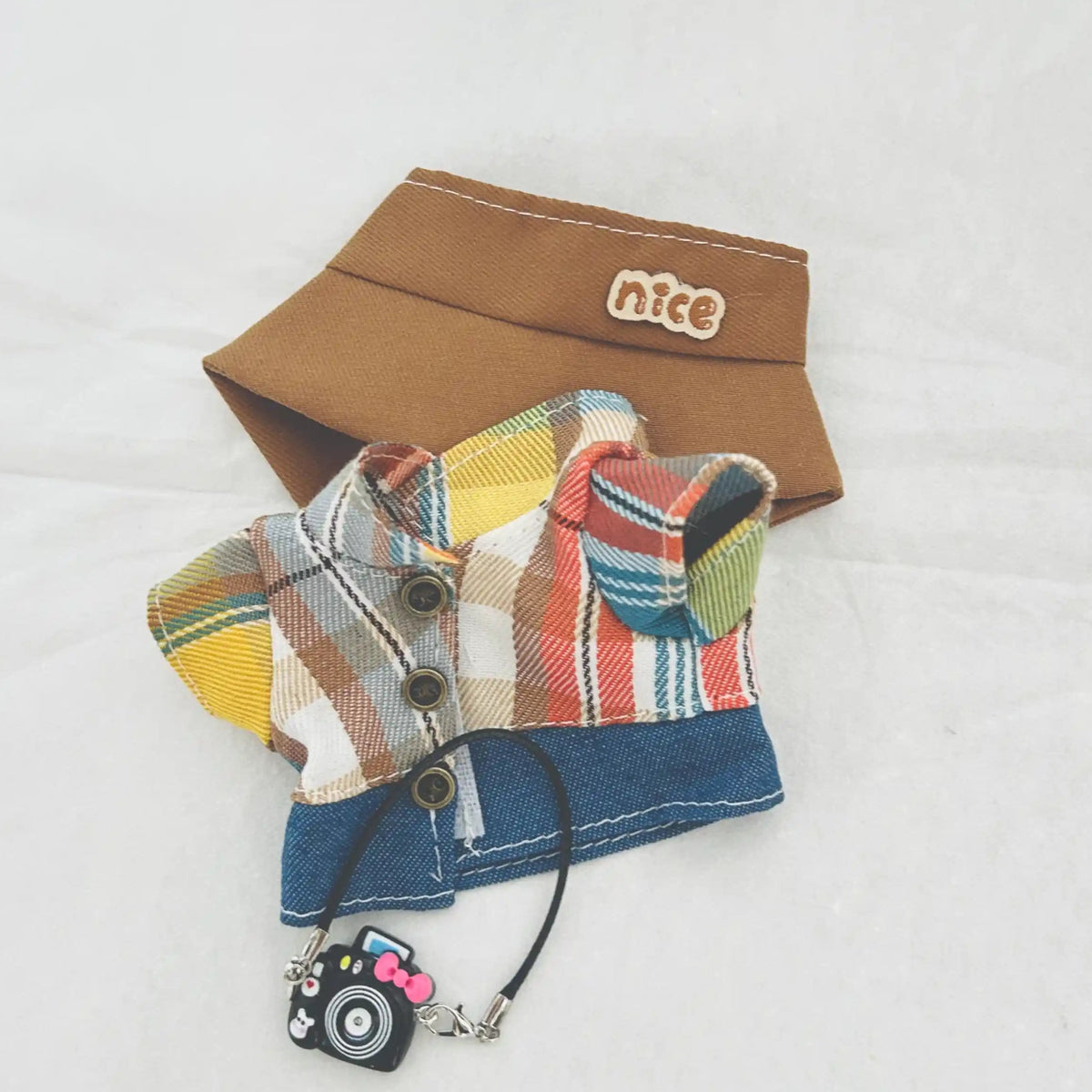 The front view of the clothing set that include plaid flannel shirt with camera charm.

