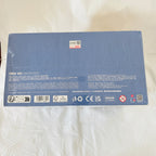 The back of a blue rectangular product box. The box contains small printed text, barcodes, recycling symbols, and compliance marks.