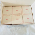Six small cream-colored product boxes arranged in a 2x3 grid inside a larger white box, each printed with the brand name 'DINOO WORLD' in red 