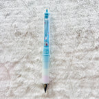A light blue and white gradient gel pen with small red and blue floral details, lying on a white textured faux fur surface.