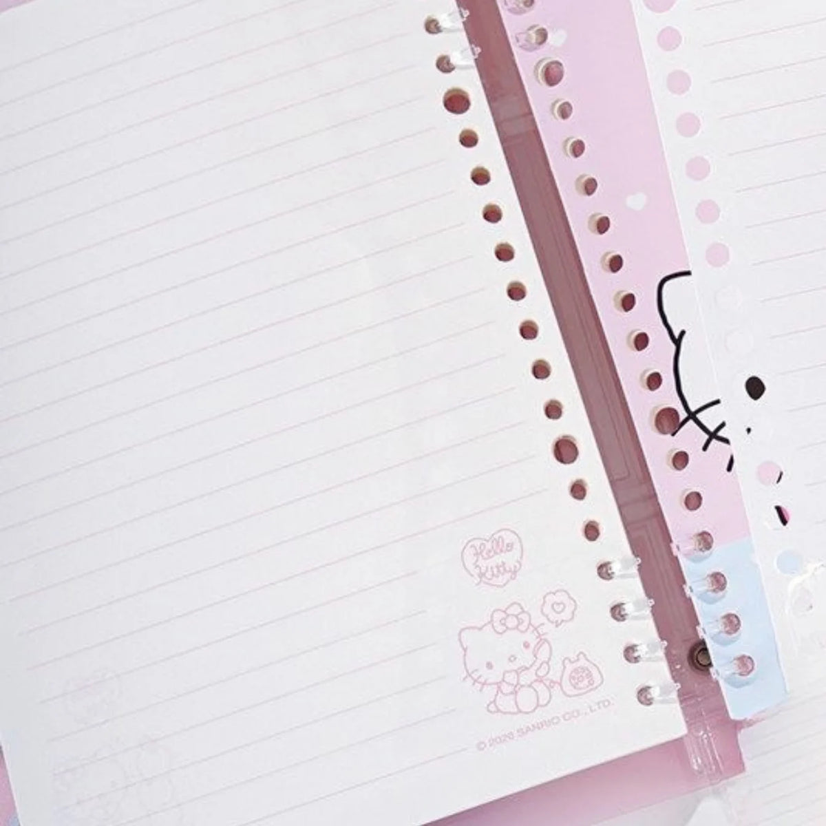 Hello Kitty lined notebook pages with a pink spiral binder and a decorative pink cover featuring Hello Kitty illustrations.