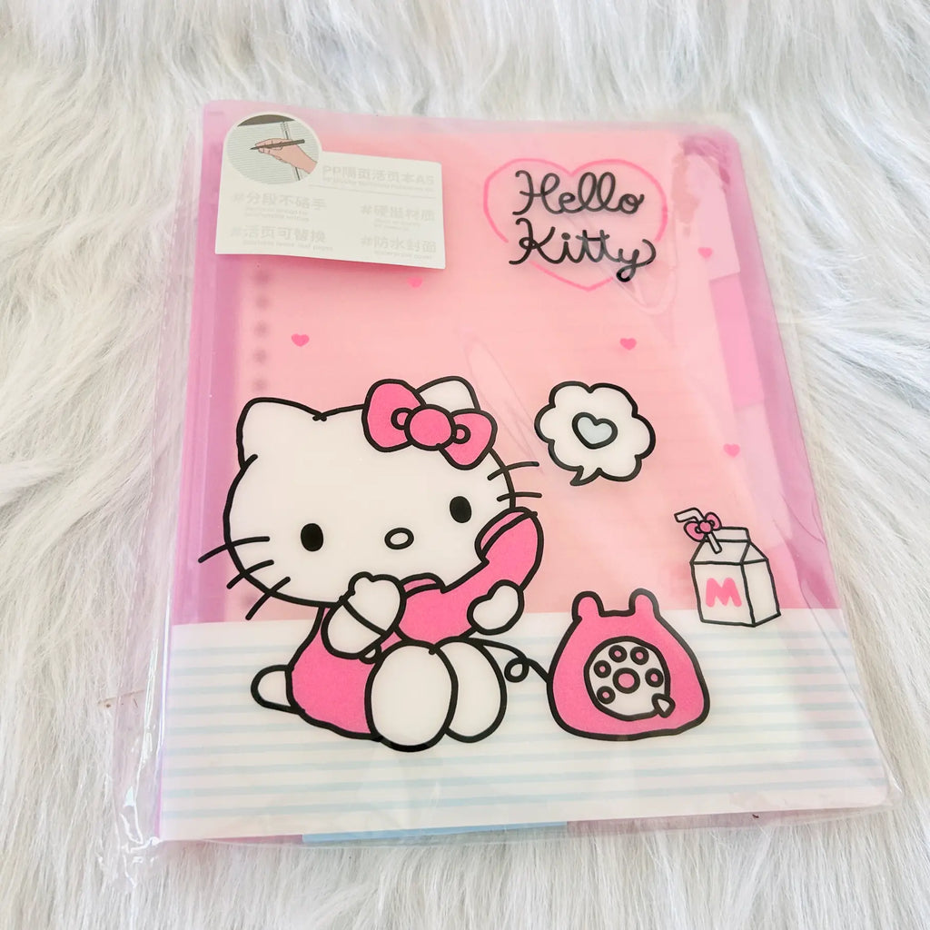 A pink Hello Kitty file folder in its clear plastic packaging,. The folder features a large illustration of Hello Kitty holding a pink phone, a pink bunny bag, and the 'Hello Kitty' logo in black script inside a pink heart.