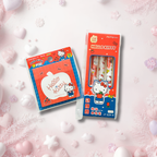 Hello Kitty stationery set featuring a pack of three pens in a clear window box and a matching notepad in a plastic sleeve, both decorated with Hello Kitty illustrations, set against a soft pink background with decorative hearts and snowflakes.