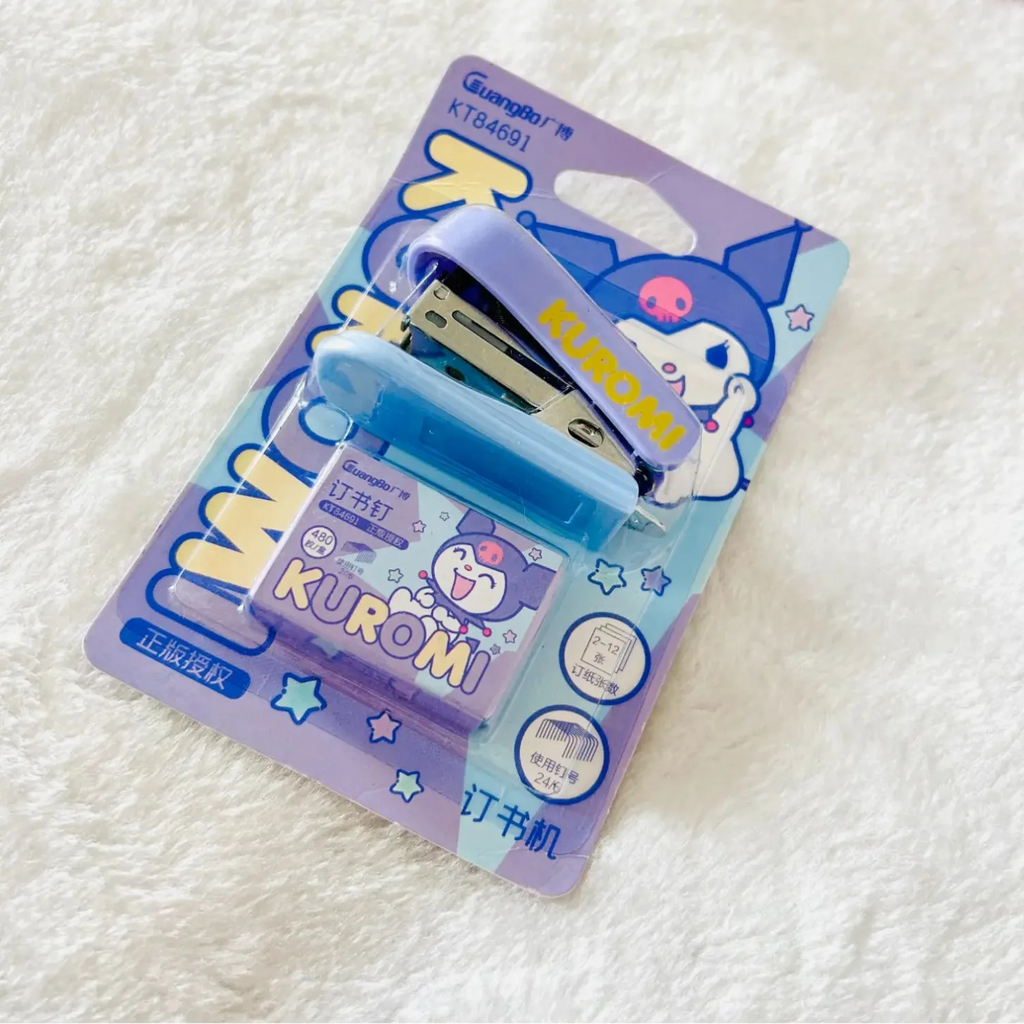Kuromi-themed stationery set in its original blister packaging, featuring a light blue stapler and a matching tape dispenser with Kuromi illustrations, placed on a soft white textured blanket.