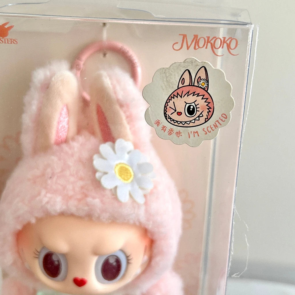 
A clear plastic box, featuring a round character sticker that reads 'MOKOKO' and 'I'M SCENTLY'.
