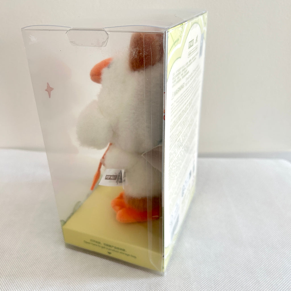 A close-up of the side of a Labubu Forest Fairy Tale plush doll which with white fur and orange feet. 
