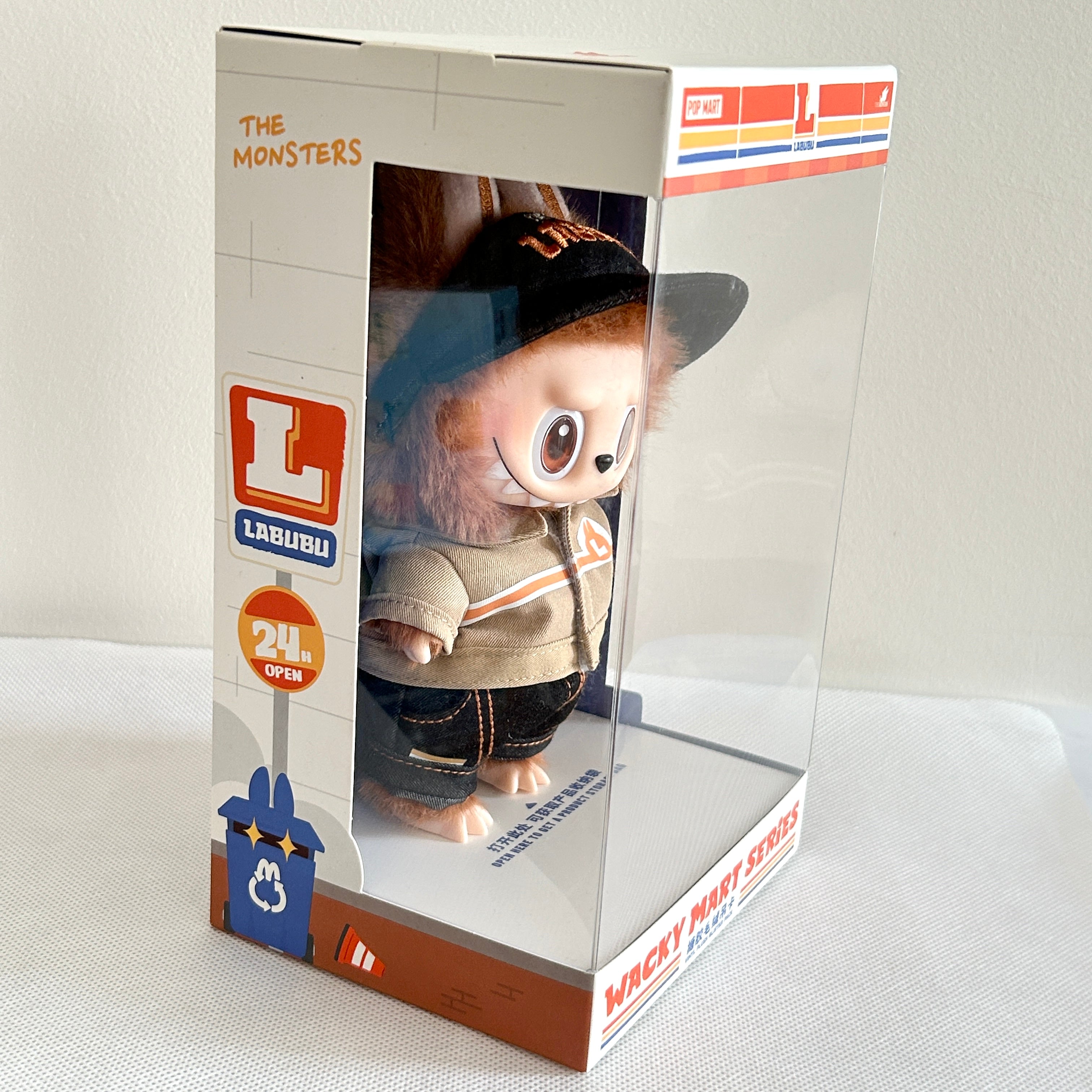 A packaged Labubu Wacky Mart Series plush, wearing a black baseball cap, beige jacket, and dark jeans.