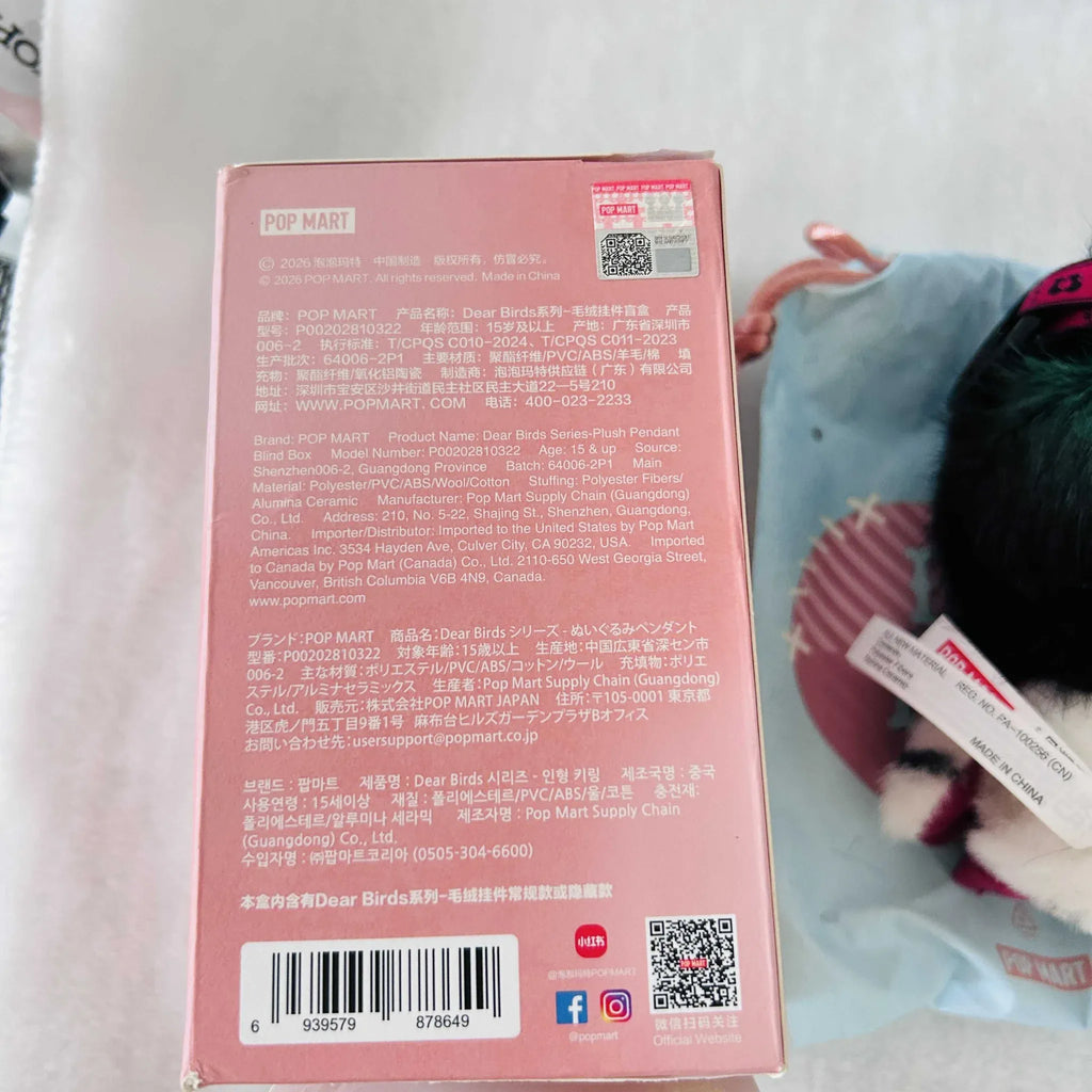 The back of a pink POP MART product box with printed text, a barcode, and a QR code.